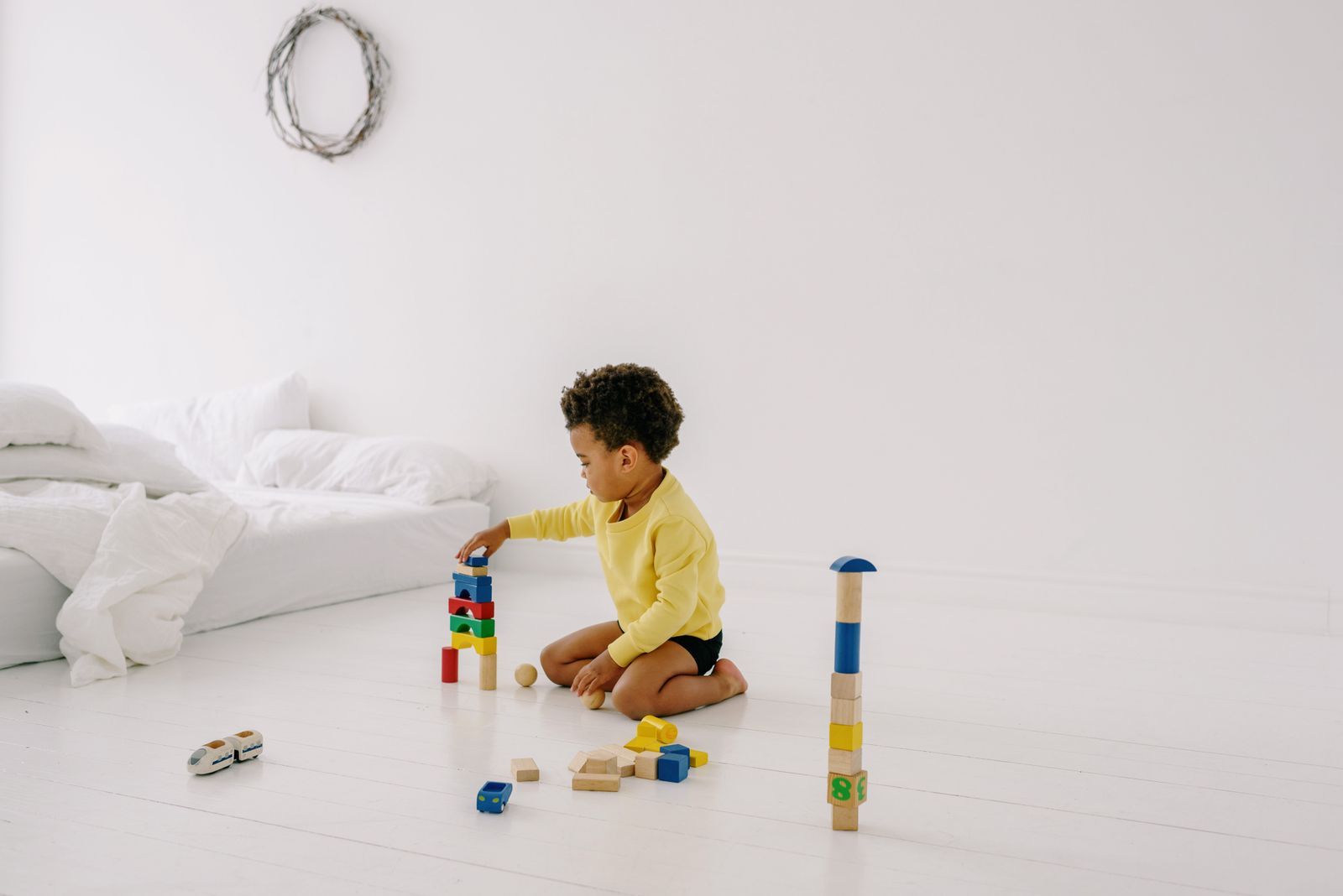 A child building with colorful blocks alongside a caregiver at Soulaani's Heart in Charlotte, NC